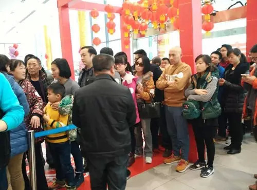 排隊(duì)領(lǐng)年貨，一家老小齊上陣。