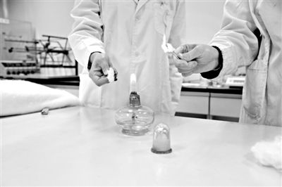 實(shí)驗(yàn)人員操作的燃燒檢測(cè)法中，真蠶絲離開火焰就熄滅(左)。