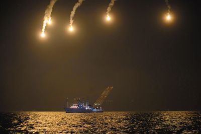 22日，搜救人員在照明彈的光亮下連夜搜救。