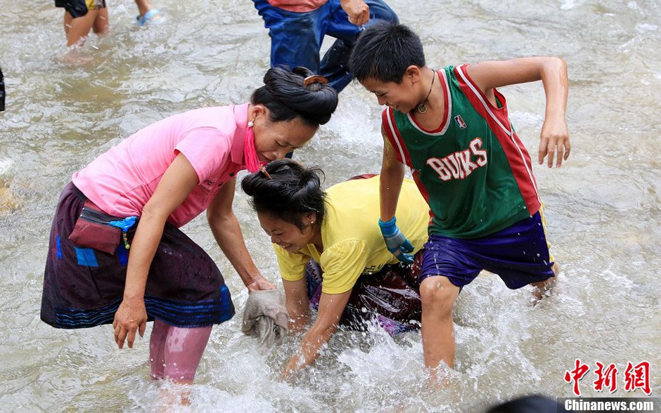 7月9日，村民在小河里摸魚搶魚。譚凱興 攝