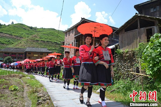 圖為新娘身著瑤族盛裝在伴娘和親友的陪伴下“出嫁”。中新社發(fā) 韋吉陽 攝