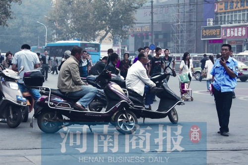 　火車站廣場北側(cè)，幾輛摩的正在等客