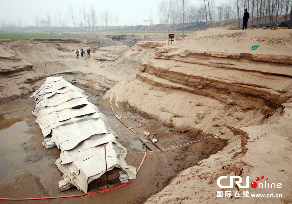 2014年1月6日，河南洛陽(yáng)古沉船發(fā)掘現(xiàn)場(chǎng)，近日有雨雪天，考古人員給古沉船披上一層“雨衣”。