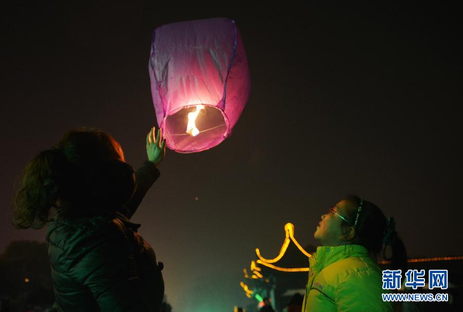 　1月30日，游客在江蘇省鎮(zhèn)江市金山公園門口放飛孔明燈。