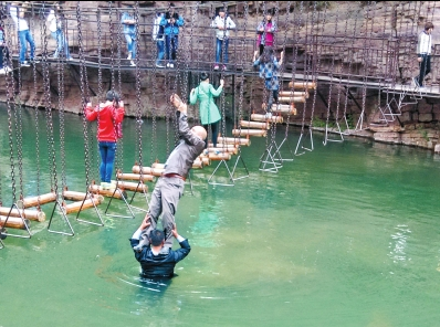 中年男游客正踩著景區(qū)安全員郭小明的肩膀過河。網(wǎng)友“@我的小名叫張孩”供圖