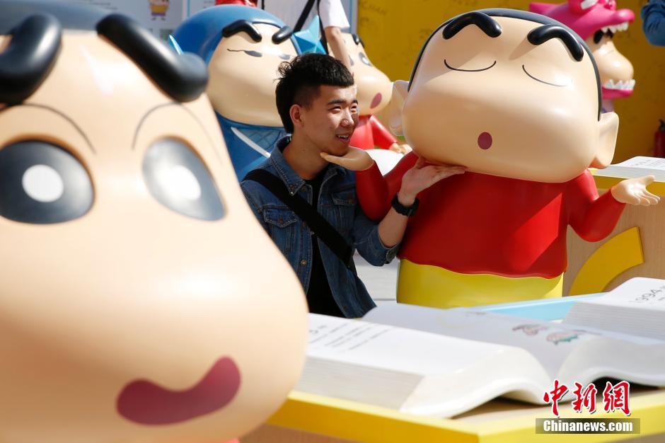 4月22日，游客與蠟筆小新合影?！跋灩P小新25周年紀念特展”日前在北京開展，吸引了不少市民游客。