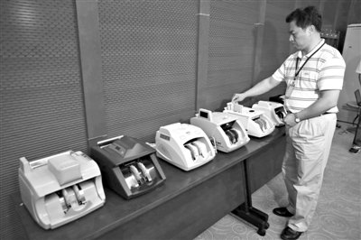 昨日，央行工作人員用各種驗(yàn)鈔機(jī)對(duì)C1F9假幣進(jìn)行測(cè)試，機(jī)器均能及時(shí)作出異常報(bào)警反應(yīng)。新京報(bào)記者 浦