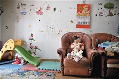 6月14日，未婚媽媽于軍的家里。女兒悅悅抱著兔子玩偶，在聽媽媽手機上的兒歌，這個4歲女孩喜歡兔子。