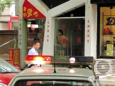 闖入面館的持刀男子與趕來的民警隔著玻璃門對峙，后店內(nèi)一名女童被其劫持。網(wǎng)友供圖
