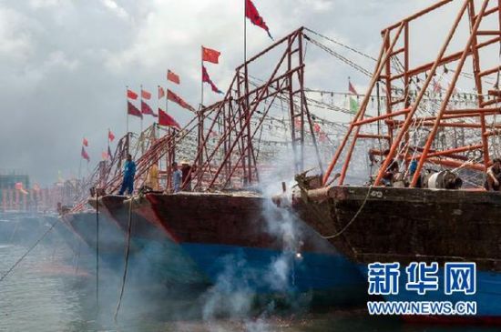2013年8月1日 南海開漁日 臨高迎新港 8月1日，海南省臨高縣漁民在船上鳴放鞭炮慶祝武蓮港開港。