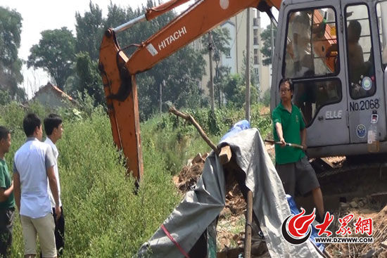 陳寶成手持自制刀斧守在挖掘機(jī)旁阻止便衣民警靠前。駕駛室內(nèi)，張朋珂正向受害人郭曉剛身上澆汽油。（視頻截圖）