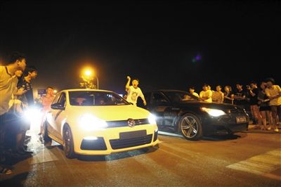 8月24日晚，東壩中街飆車現(xiàn)場，兩輛車并排等待出發(fā)指令，旁邊許多愛好者前來觀看比賽。新京報(bào)記者