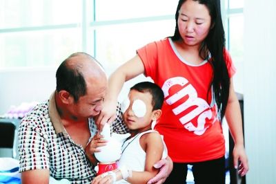 斌斌手術(shù)后第一天恢復(fù)良好，斌斌父母在用玩具逗他開心供圖/嚴(yán)益