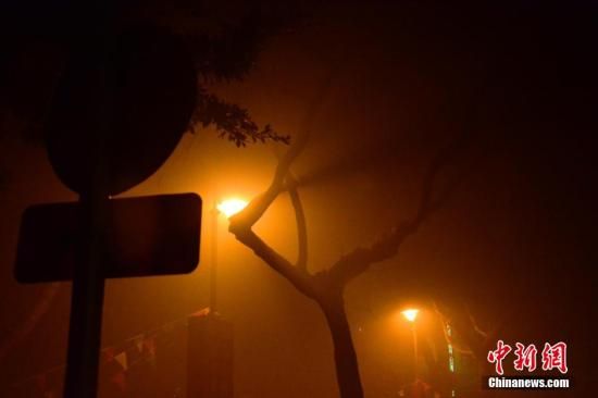 1月31日凌晨，市民行走在煙霧繚繞的南京街頭。當(dāng)天是農(nóng)歷馬年正月初一，南京有限開禁燃放煙花爆竹正逢下霧天，空氣的不流通致使煙花爆竹燃燒后產(chǎn)生的顆粒物不能及時散開，造成整座城市煙霧繚繞。據(jù)當(dāng)?shù)丨h(huán)保部門發(fā)布的信息顯示，空氣質(zhì)量屬重度污染。中新社發(fā) 泱波 攝