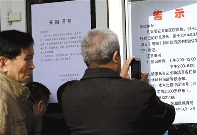 昨日，家長(zhǎng)在西安市楓韻幼兒園查看有關(guān)兒童體檢的告示。