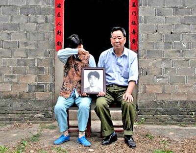 江蘇鎮(zhèn)江，老劉夫婦捧著獨(dú)生子的遺像在老家前留影南方都市報(bào)供圖L