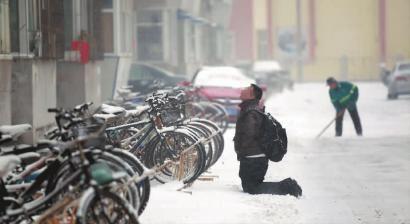 小伙子跪在樓前，一直抬頭看著樓上。 孫立國(guó)/攝