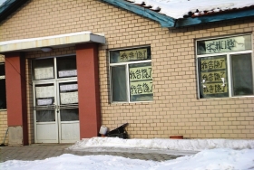 伊春市帶嶺區(qū)一排破舊的平房，房間窗戶上貼滿了“我告饒了”的字樣。