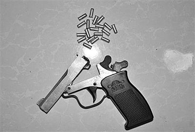 警方從搶劫嫌疑人處起獲的贓款和發(fā)令槍、子彈。警方供圖