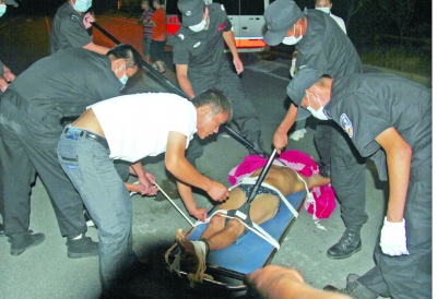 眾人合力將狂犬病發(fā)作的江某控制住。 孫東城 攝