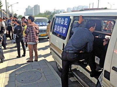 昨日，朝陽區(qū)看守所門前有人排隊。大門外還停有多輛寫有“律師會見”字樣的車。