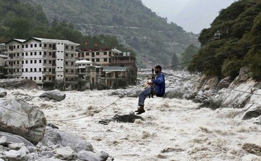 一名印度男子靠繩索渡河。