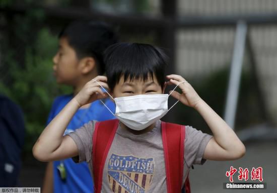 圖為當(dāng)?shù)貢r(shí)間2015年6月8日，韓國未停課的學(xué)校，學(xué)生課前戴口罩測體溫。