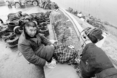 　出事司機(jī)的鞋找不到了，只好用塑料袋套著腳取暖