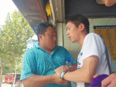 記者正查看照片，突遭藍(lán)衣男強(qiáng)搶手機(jī)。