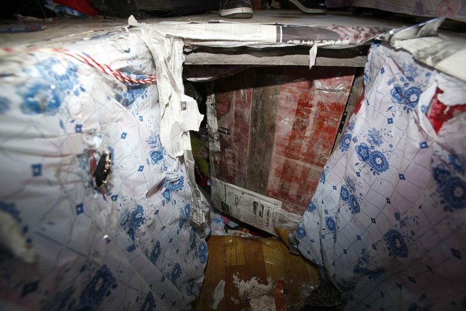 陳小龍?jiān)诔鲎馕萃?，自行又圍起一堵圍墻，安裝了一個(gè)門。圍墻上都是豎起的鐵釘，外面堆著土，鄰居猜是從地底挖出來(lái)的。洞口就在床邊，0.5米見(jiàn)方，深約1.5米。洞口表面一塊紙板掩蓋，打開(kāi)紙板跳入洞底，是一扇小木門，木門外有插銷，可以從外面鎖上。