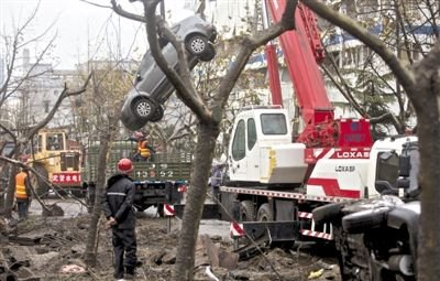 輸油管道爆炸后，搶修人員將被炸毀的車輛運出現(xiàn)場。
