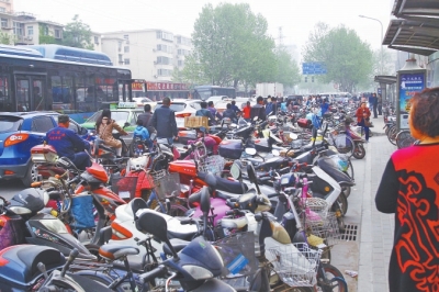 省人民醫(yī)院北門，路邊的公交站牌處停滿非機(jī)動(dòng)車，上、下客只能在快車道上。