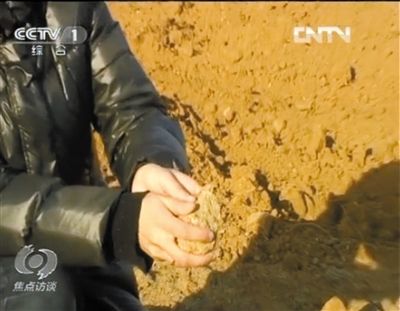 麻剛沙系麻剛石粉碎而成。記者找到一塊麻剛石，一捏就碎成粉末，硬度非常差。央視截圖