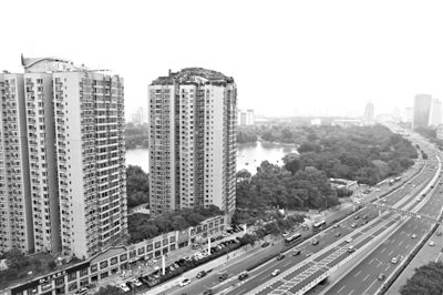 昨日，人濟(jì)山莊小區(qū)，與其他樓相比，B棟樓頂層天臺上違規(guī)建造了一棟兩層小樓，假山大樹俱全。新京報(bào)記者