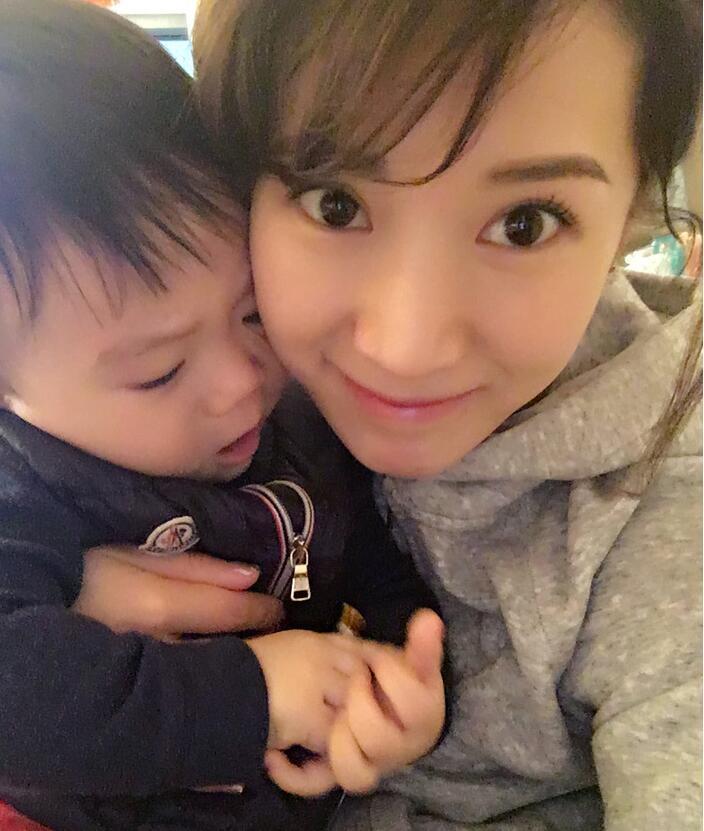 照片中李念狂吻兒子，小寶貝自顧自地玩著。