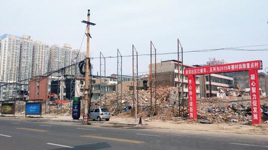 015年5月31日，在社區(qū)干部的帶頭拆遷下，親賢社區(qū)的“城中村改造”拉開帷幕。由于前期“清產(chǎn)核資”及補(bǔ)償標(biāo)準(zhǔn)等因素，拆遷改造工作推進(jìn)并不順利。圖為位于體育西路東側(cè)集體所有的商鋪率先被拆遷完畢，用于遮擋的圍擋正在施工中。（拍攝：2015年9月16日）