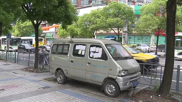 被棄置在人行道上的面包車(chē)。