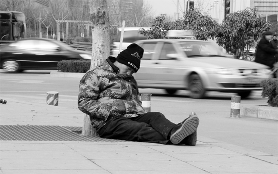 2月2日，鄭州市中州大道農(nóng)業(yè)路立交橋下，50歲的王文德打算在臨近春節(jié)前再接些零活兒，由于疲憊，他睡著