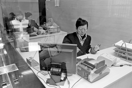 2月16日，鄭州市自來水總公司鄭東新區(qū)一營業(yè)廳，柜臺內工作人員正在為市民辦理業(yè)務