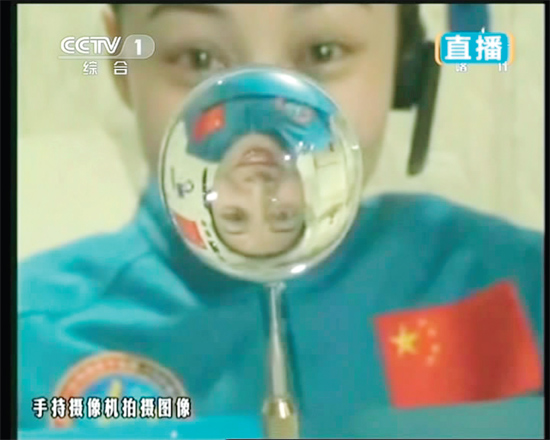 王亞平的倒影出現(xiàn)在水球中。新華社發(fā)（視頻截圖）