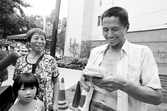 昨日，鄭州市明達(dá)路與豐慶路交叉口西300米路南，來自中牟的瓜農(nóng)拿到西瓜款，笑開顏東方今報(bào)記者袁曉強(qiáng)