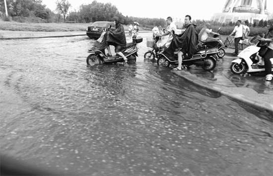 8月7日，鄭州一場(chǎng)暴雨，鄭州多處干道被淹，市民行路如過河
