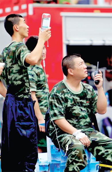 火場外，被消防戰(zhàn)士稱為“李大隊”的救援人員掛著吊瓶現(xiàn)場指揮