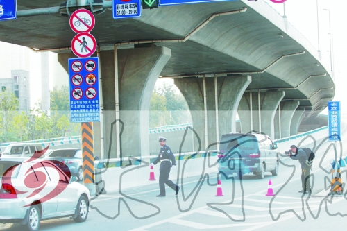 交警在東風(fēng)路從北向南上橋口處擺上反光錐，間歇放行