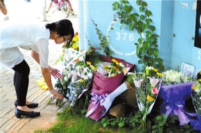 6月8日下午，記者來到廈門公交車爆炸事發(fā)現(xiàn)場橋下，附近已聚集了十幾個自發(fā)前來悼念的市民。橋墩下排放了一圈或黃或白的菊花，還有玖瑰、百合等。