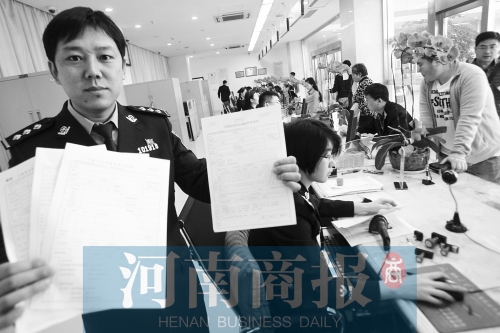 　民警左手拿的是新申請表，右手拿的是三份老申請表 王春勝/攝