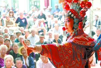 圖為8月15日戲曲演員在“流動舞臺車”上表演傳統(tǒng)地方戲《穆桂英下山》。