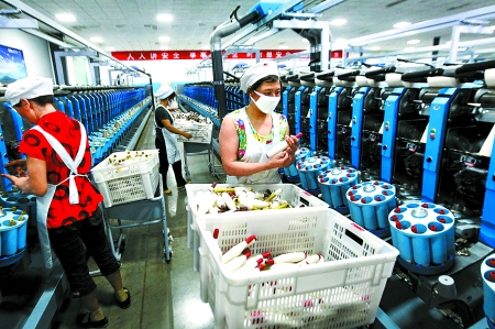 6月6日，舞鋼市鑫海紡織有限公司員工正在新建成的紡紗車間生產(chǎn)。