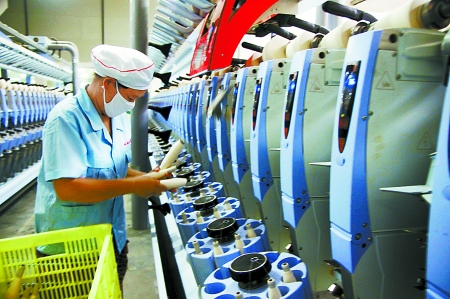 7月3日，在鄧州市永泰棉紡有限公司電腦控制全自動紡紗車間，紡織工人正在生產(chǎn)棉紗。