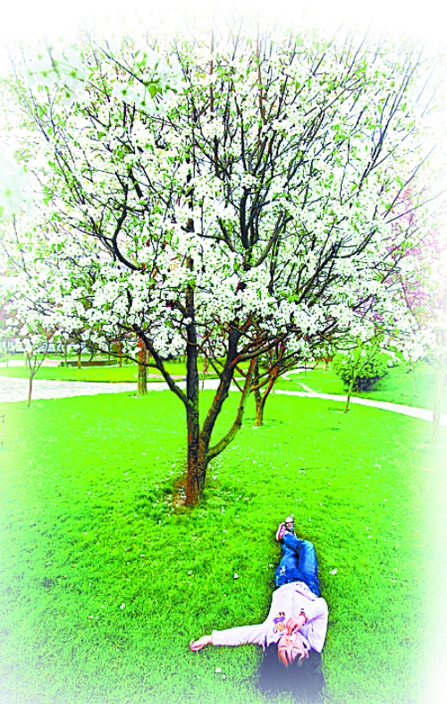 　孩子愜意地躺在社區(qū)內(nèi)的草坪上。